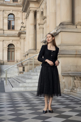 a lady in a black wool jacket and a black long tulle skirt